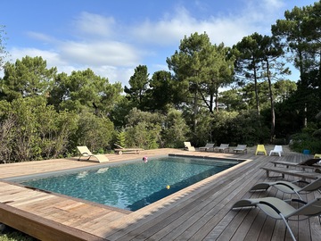 Piscine traditionnelle 10x5 pyla sur mer membrane armée anthracite avec volet immergé dans la plage terrasse  en bois exotique IPE